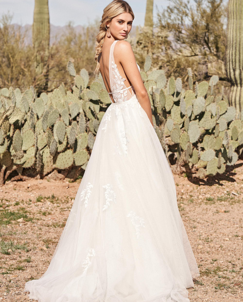 Model in the dessert wearing a boho wedding dress made of soft tulle with a double band waist. Made by Lillian west and available at Brides Of Southampton